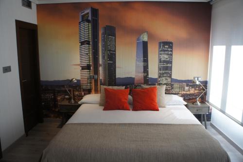 马德里阿瑞赞尼卡套房公寓的一间卧室配有一张大床,挂有摩天大楼壁画