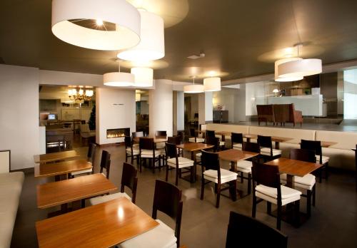 波尔图波尔图安塔斯酒店的用餐室配有木桌和椅子