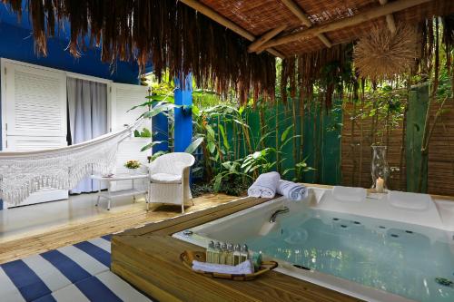 托兰克索Pousada Tangará的带花园的客房内的按摩浴缸