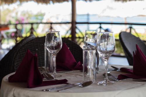 达累斯萨拉姆地标美兹海滩度假酒店的一张桌子,上面放有酒杯和餐巾