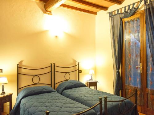 格罗塞托港伊尔鲁斯蒂科乡村民宿的一间卧室配有一张蓝色棉被的床