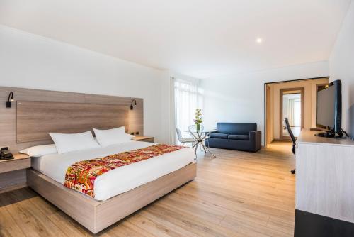 波哥大罗萨莱斯广场酒店的一间卧室配有一张大床和电视