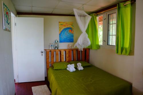 Isla Cebaco Cebaco Sunrise Lodge的一间卧室,配有一张绿床,上面有两只填充动物