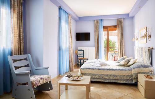 欧拉努波利斯Archodiko Toliadi Boutique Apartments and Suites的卧室拥有蓝色的墙壁,配有一张床和椅子