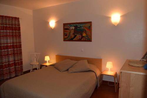 卢斯Casa da Praia | Luz Beach的卧室配有一张床,墙上有两盏灯