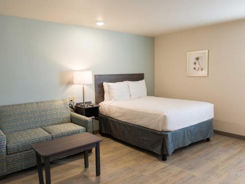 塔尔萨WoodSpring Suites Broken Arrow的酒店客房,配有床和沙发