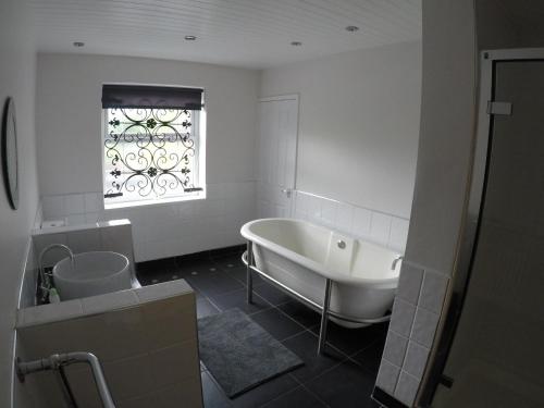 WylamThe Boathouse Wylam的白色的浴室设有浴缸和窗户。