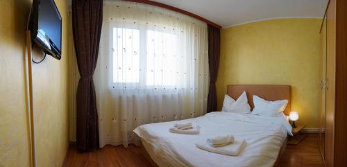 康斯坦察Cazare-Mamaia RO的一间卧室配有一张床,上面有两条毛巾