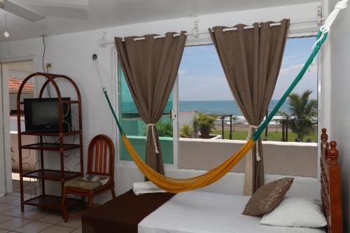查察拉卡斯Hotel Arrecife Chachalacas的一间带吊床的卧室,享有海景