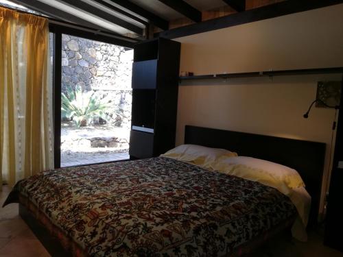 格拉维纳迪卡塔尼亚Lily house的一间卧室设有一张床和一个大窗户