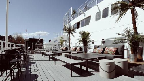 斯德哥尔摩Rygerfjord Hotel & Hostel的庭院设有桌子、长凳和小船