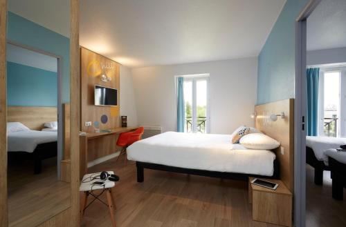 瓦朗西纳宝度酒店的酒店客房,配有床和镜子
