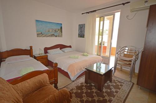 乌尔齐尼德约科维奇公寓酒店的一间带两张床和一张沙发的客厅