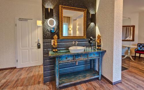 吕本瑙SPREE Hotel in der Altstadt的浴室设有水槽和墙上的镜子