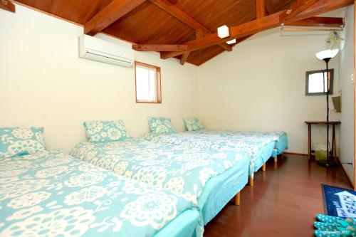 ShishikuiPavilionSurf&Lodge的配有木天花板的客房设有两张床。