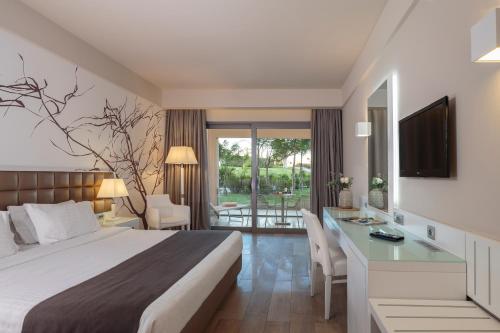 吉奥塔略Princess Andriana Resort & Spa - Ultra All-Inclusive的酒店客房配有一张床、一张书桌和一台电视。
