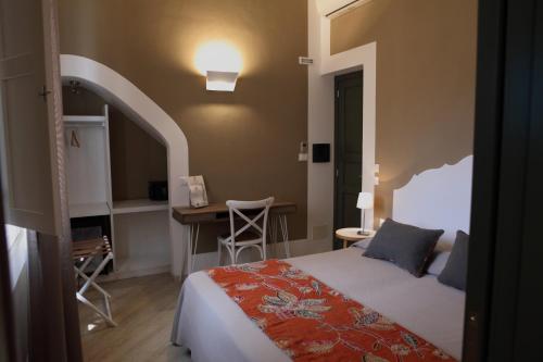 法维尼亚纳艾古萨酒店的一间卧室配有一张床、一张桌子和一张桌子