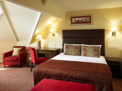 布莱克浦布莱克浦帝国酒店的酒店客房配有一张床、一张桌子和一把椅子。