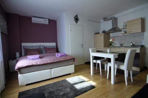萨格勒布Apartment Mavero-Free Private Parking的一间卧室配有一张床铺和一张桌子,还设有一间厨房
