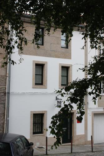 圣地亚哥－德孔波斯特拉Casa Do Medio的白色的建筑,窗户在建筑的一侧