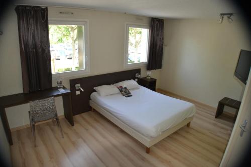 科尔马Hotel Primo Colmar Centre的一间卧室配有一张床、一张书桌和两个窗户。