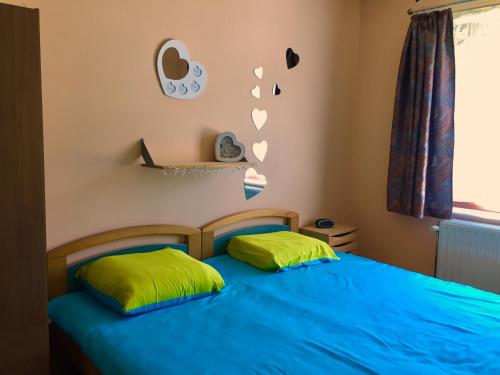 Jemeppe瓦丁度假屋的一间卧室配有蓝色的床和两个绿色枕头
