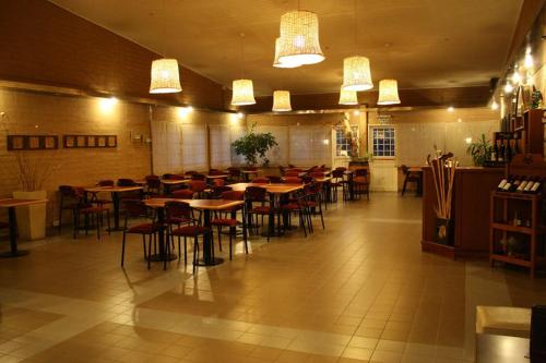 罗卡将军市Hotel La Fundacion的一间大房间,餐厅内摆放着桌椅