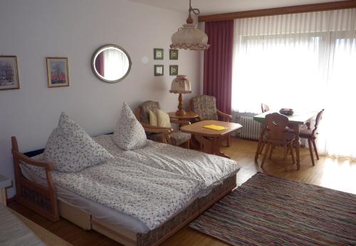 法尔先特Farchant-Zugspitze的一间卧室配有一张床,客厅配有桌子