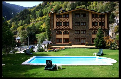 阿林萨尔维尔杜小屋酒店的一座大建筑,在草地上设有一个游泳池