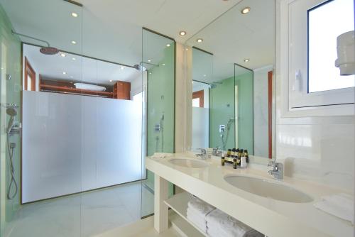 罗德镇宜必斯库斯酒店的一间带两个盥洗盆和大镜子的浴室