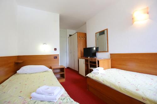LukaHotel Luka的酒店客房设有两张床和电视。