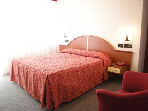 Albino瓦莱多奥尔酒店的配有一张床和一把椅子的酒店客房