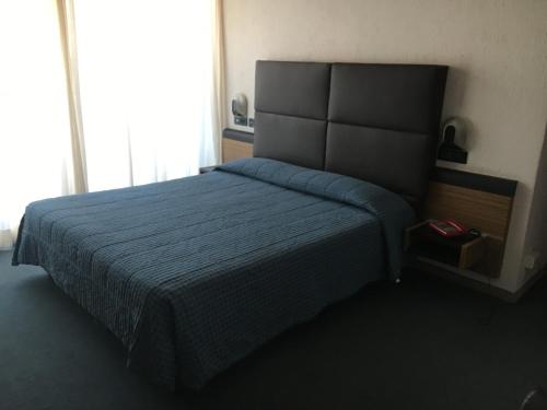Albino瓦莱多奥尔酒店的一间卧室配有一张带蓝色床罩的床