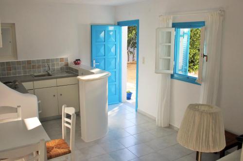 洛加拉斯Meltemi Studios and Apartments的厨房设有蓝色门和水槽
