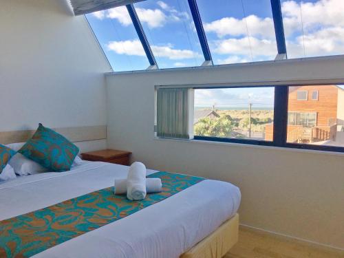 基督城海滨生活公寓酒店的一间卧室设有两张床和大窗户