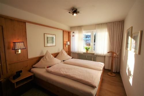奥伯斯特多夫Alpenflair Ferienwohnungen Whg 202的一间卧室设有一张床和一个窗口