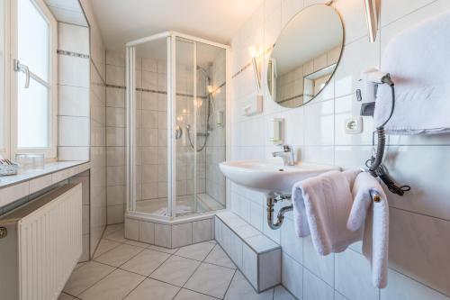 上施陶芬Hotel Neudeck的白色的浴室设有水槽和淋浴。
