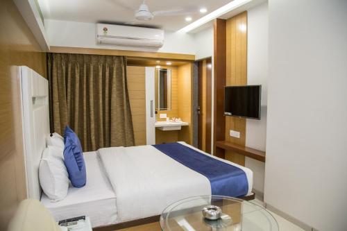 苏拉特桔子国际酒店的一间酒店客房,配有一张床和一台电视