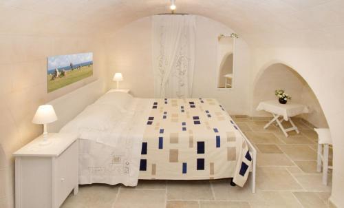 莫诺波利Locazione turistica Casa Liù的白色卧室配有一张大床和一张书桌