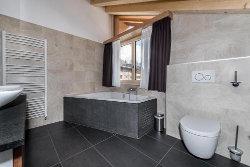 贝尔瓦尔德翁雅度假Spa酒店的带浴缸、卫生间和盥洗盆的浴室