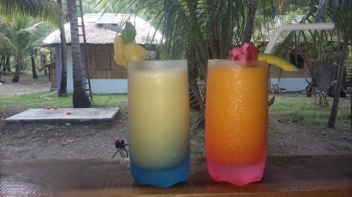 Sablayan萨布拉延帕拉伊索海滩度假酒店的木桌边的两杯饮料
