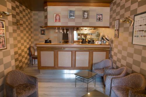 Bléneau布兰奇卡斯提尔酒店的餐厅内的酒吧配有两把椅子和一张桌子