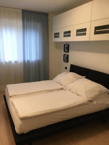 加尔达湖滨Appartamento al Fiume的一间卧室设有两张带白色床单的床和窗户。