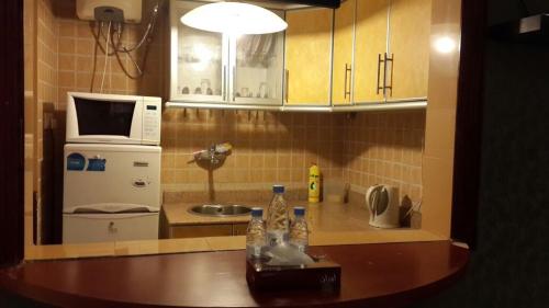 巴哈Almeswari Suites的一间带水槽和微波炉的小厨房