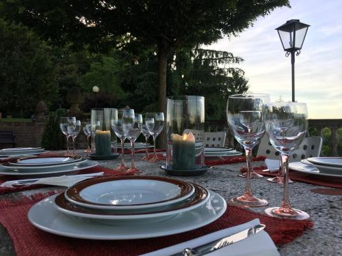 Ozzano Monferrato毗邻四季住宿加早餐旅馆的一张桌子上放有盘子和酒杯