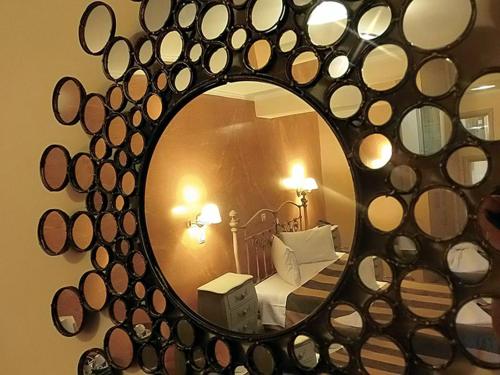 波罗斯安娜斯塔贾酒店的卧室内的镜子,卧室配有一张床和一张床