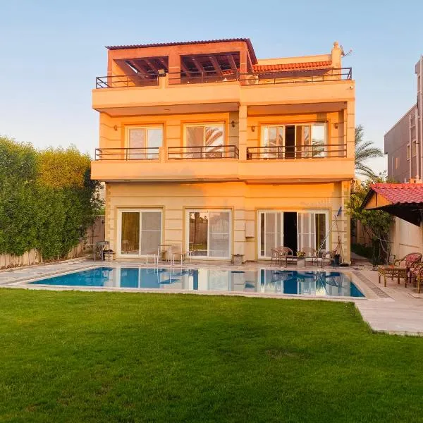 Lovely Villa 5- bedroom with Overflow Pool with Nice Garden at Green Oasis Resort，位于Dawwār Abū al ‘Āşī的酒店