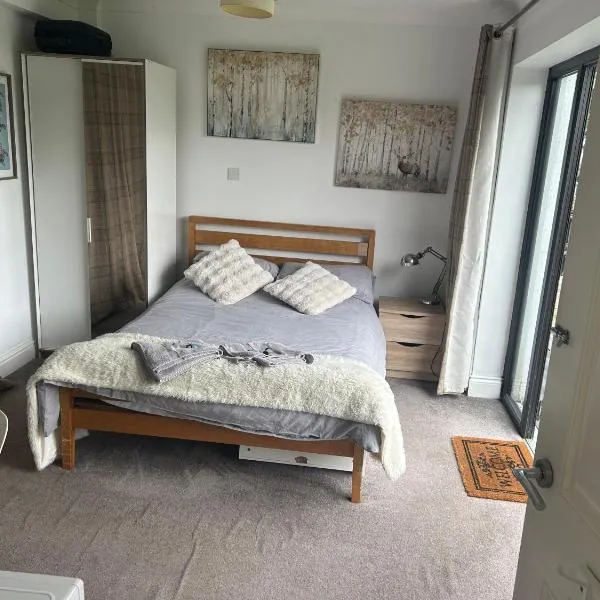 We have 2 rooms to offer at our home - there is a very large downstairs bedroom with ensuite OR a beautiful bar b q lodge with 4 sleeping platforms with its own separate toilet and shower facility opposite the lodge - please book the room you want，位于波蒂斯黑德的酒店